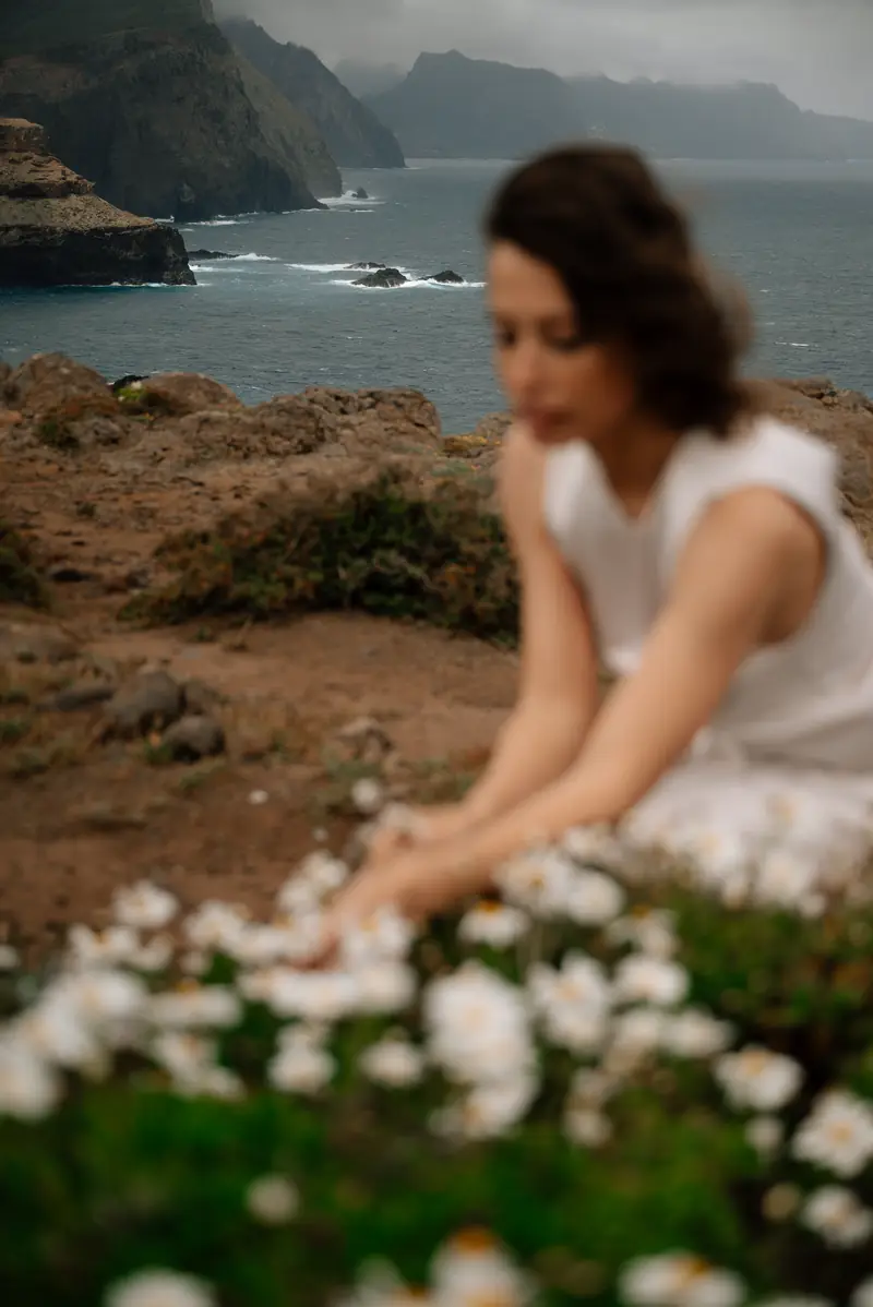 Portrait among white wildflowers by the ocean