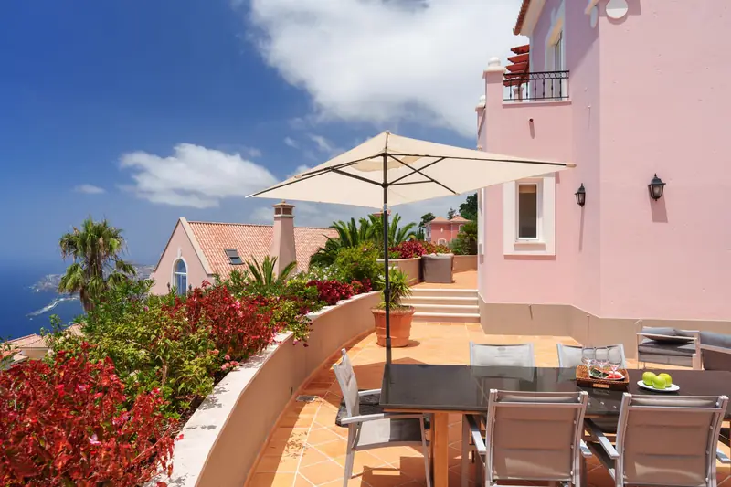 A villa terrace with a dining table and a view of the ocean